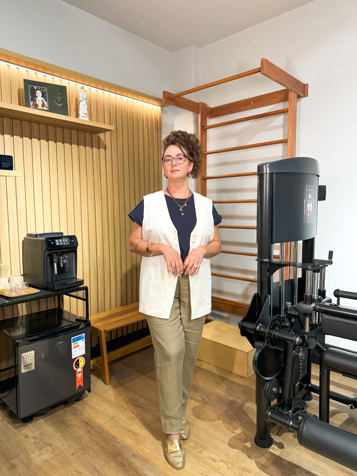 foto da Dra Bruna Bacchini em seu estúdio com alguns equipamentos ao fundo