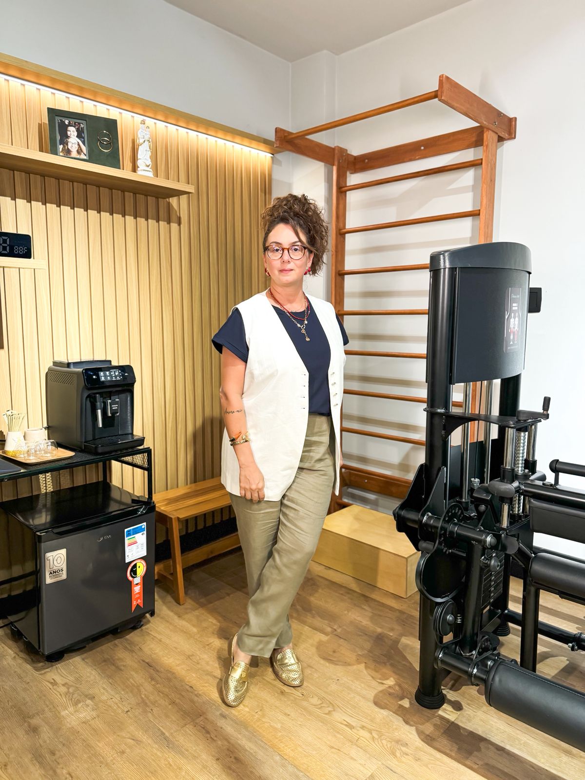 foto da Dra Bruna Bacchini em seu estúdio com alguns equipamentos ao fundo