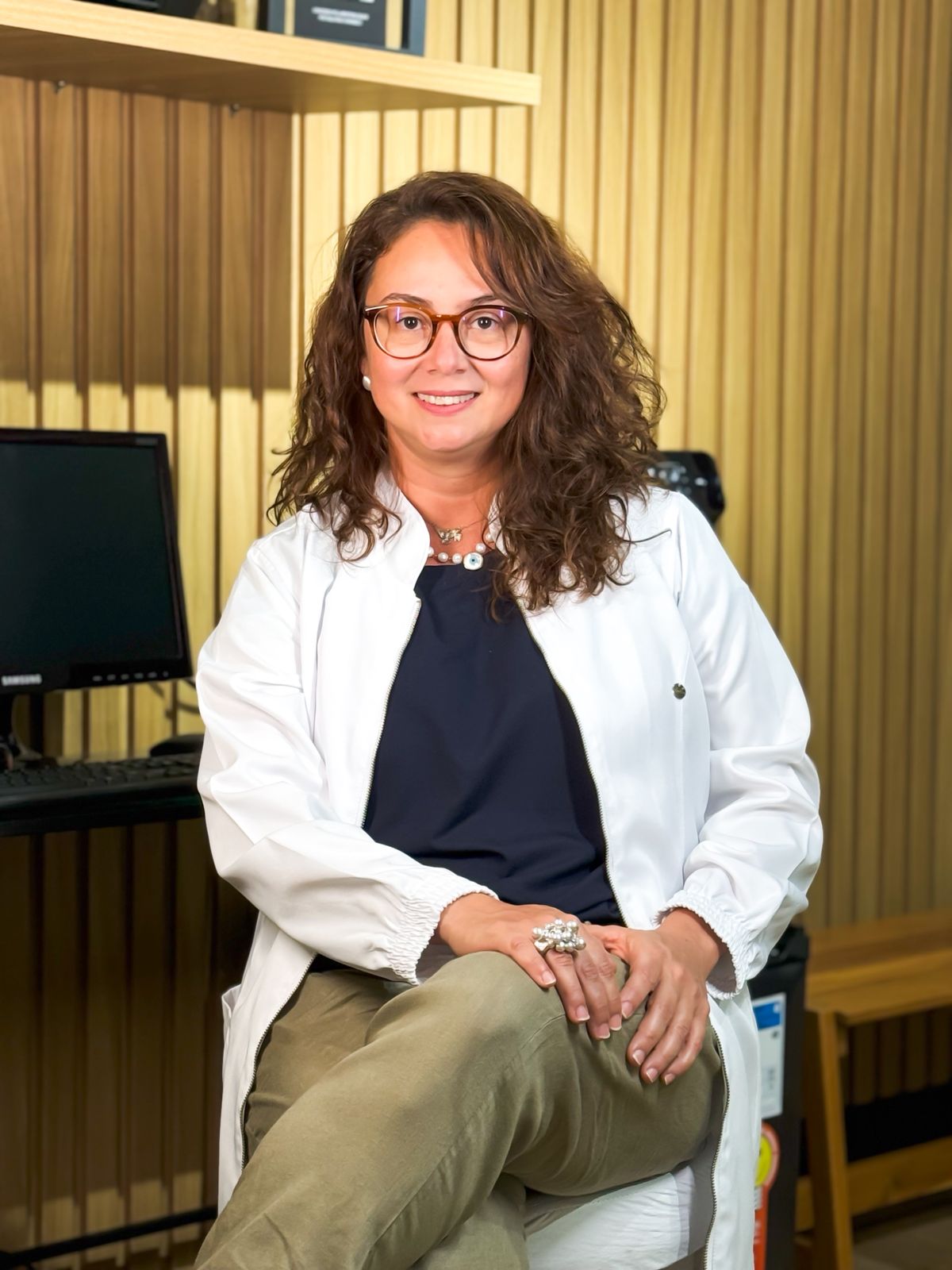 foto da Dra Bruna Bacchini sentada em seu estúdio de fisioterapia respiratória